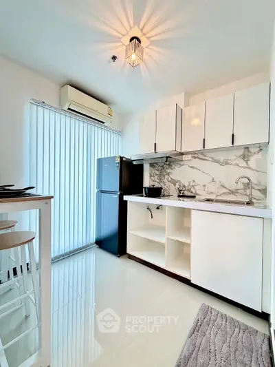 Modern kitchen with sleek cabinets and marble backsplash in bright apartment