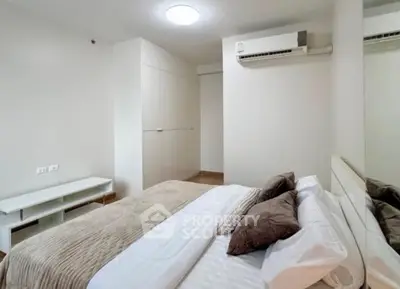 Modern bedroom with neutral tones and air conditioning in a stylish apartment.