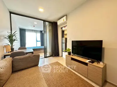 Modern living room with cozy sofa and TV, open layout to bedroom, perfect for urban living.