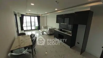 Modern living room with open kitchen and balcony view in a stylish apartment.