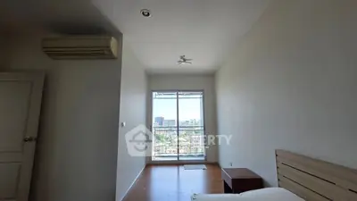 Spacious bedroom with city view and natural light, featuring modern air conditioning.