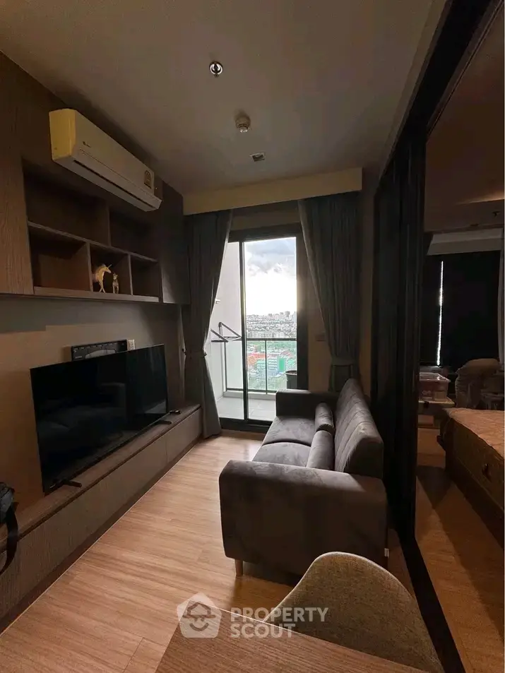 Modern living room with balcony view, featuring sleek furniture and natural light.