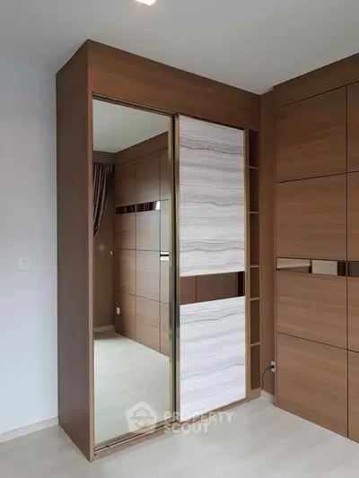 Modern bedroom with sleek wooden wardrobe and sliding doors