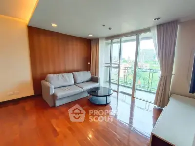 Spacious living room with modern sofa and large windows offering a stunning city view.