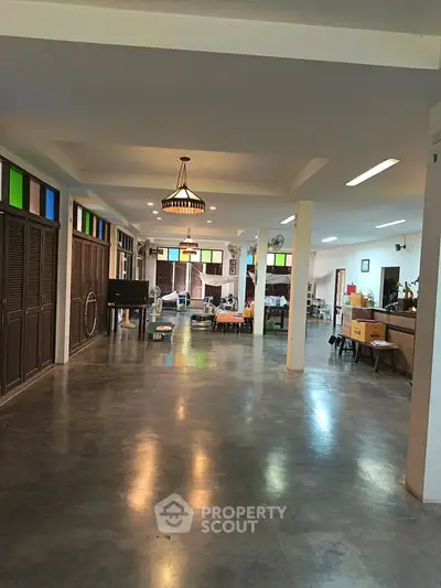 Spacious open-plan living area with polished concrete floors and colorful stained glass windows.