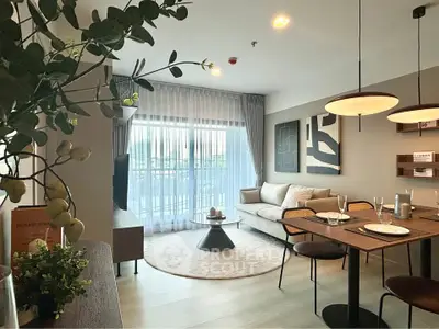 Modern living room with stylish decor and dining area, featuring large windows and elegant lighting.