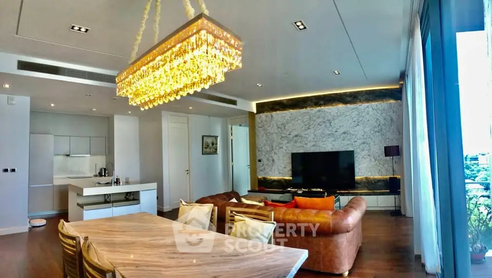 Luxurious living room with elegant chandelier and modern open kitchen layout