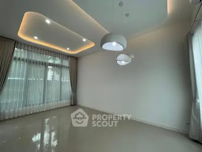 Spacious modern living room with elegant lighting and large windows.