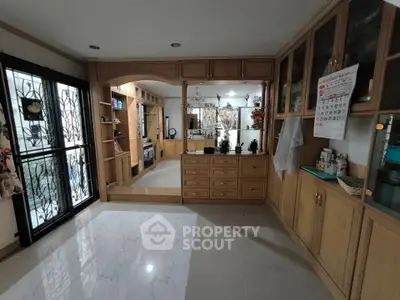 Spacious living room with elegant wooden cabinetry and large windows
