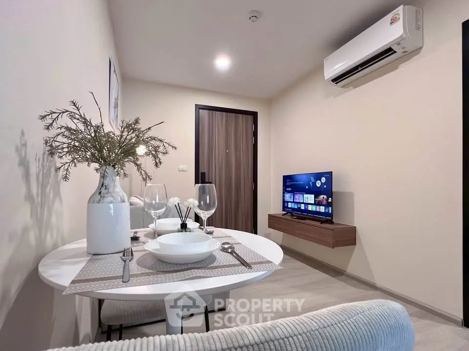 Modern living room with dining area, featuring sleek furniture and wall-mounted TV for a cozy ambiance.