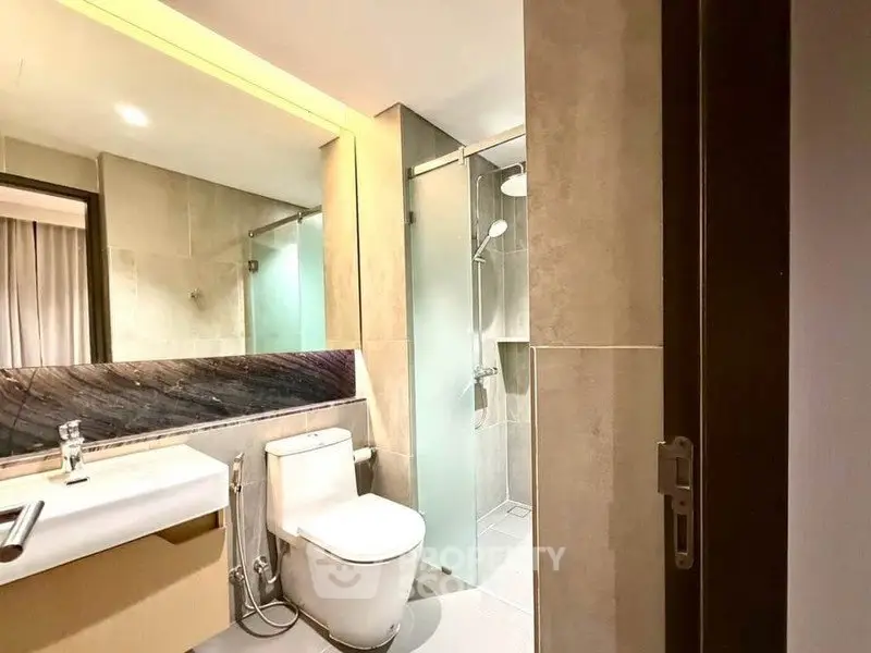 Modern bathroom with glass shower and sleek fixtures in a contemporary apartment.