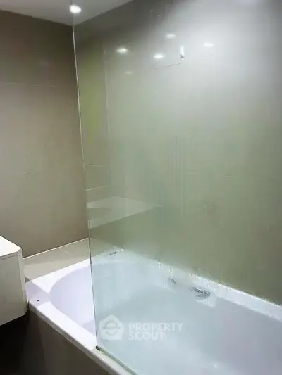 Modern bathroom with sleek glass shower partition and bathtub