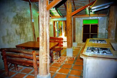 Rustic kitchen with wooden furniture and gas stove in cozy cabin setting.
