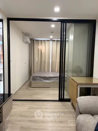 Modern bedroom with sliding glass doors and elegant decor in a stylish apartment.