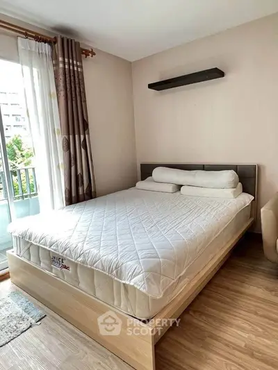 Cozy bedroom with modern decor and balcony access in a stylish apartment.