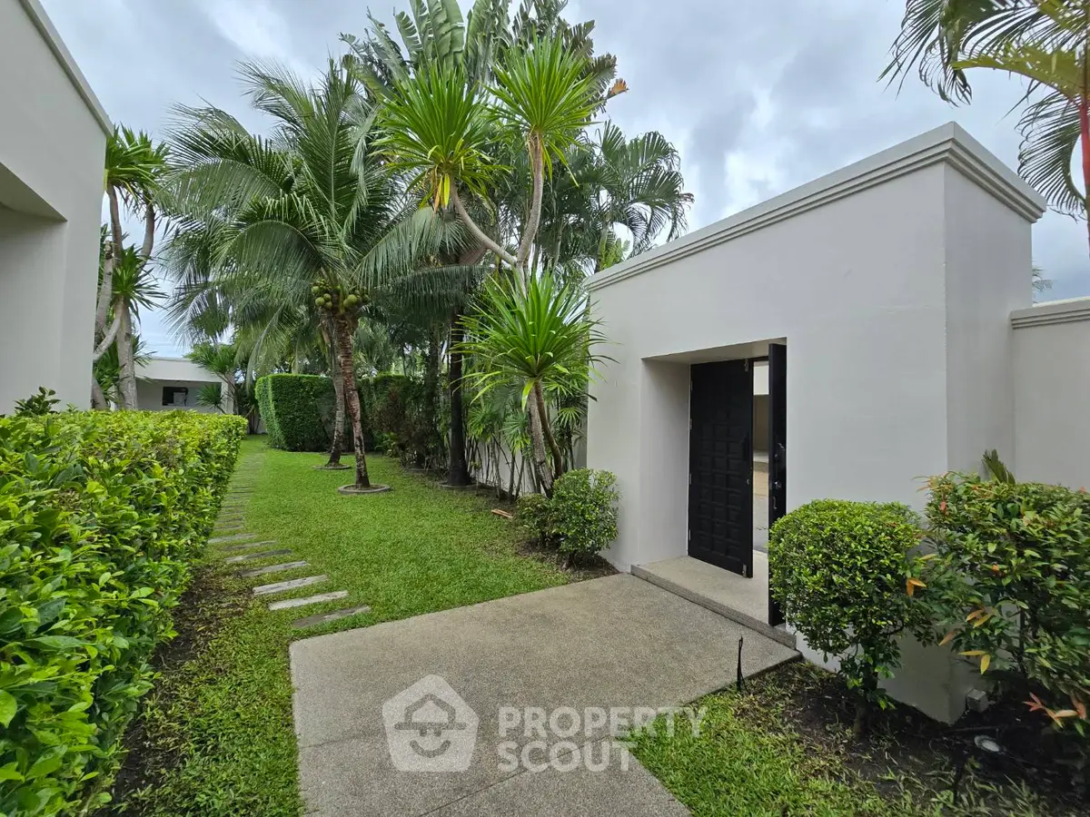 Tropical garden entrance with lush greenery and modern architecture