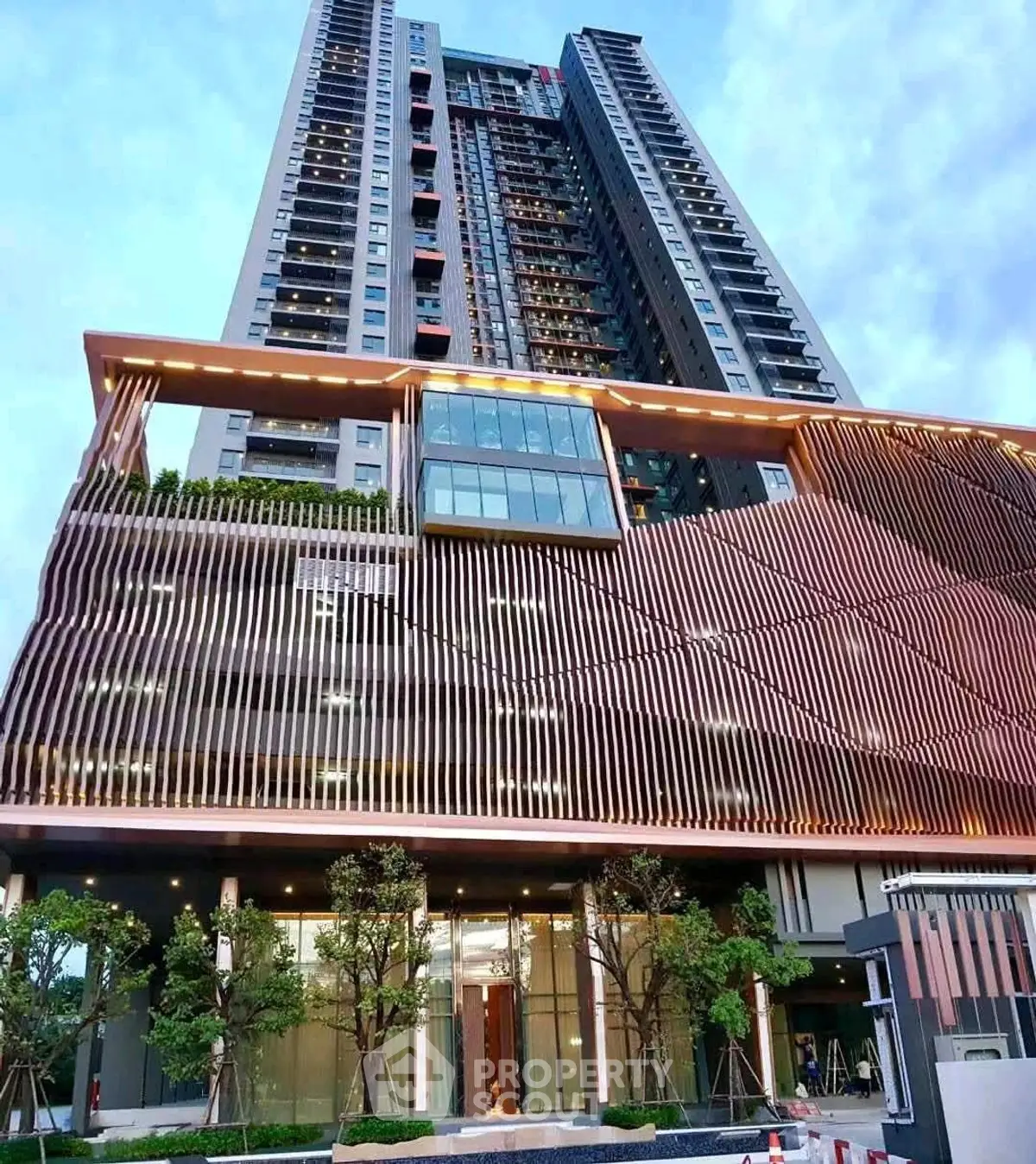 Stunning modern high-rise building with unique architectural design and lush greenery.