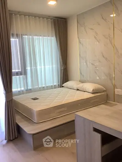 Modern bedroom with stylish decor and natural light, featuring a comfortable bed and elegant curtains.