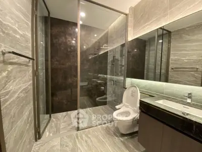 Luxurious modern bathroom with sleek marble tiles and glass shower enclosure.