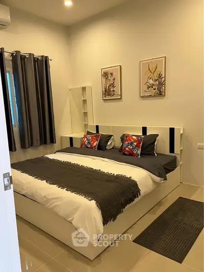Modern bedroom with stylish decor and cozy ambiance, featuring elegant artwork and plush bedding.