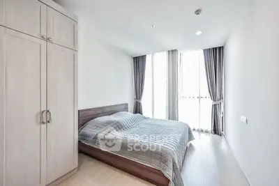 Spacious bedroom with modern design and natural light from large windows.