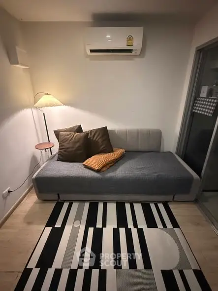 Cozy living room with modern decor and air conditioning, perfect for relaxation.