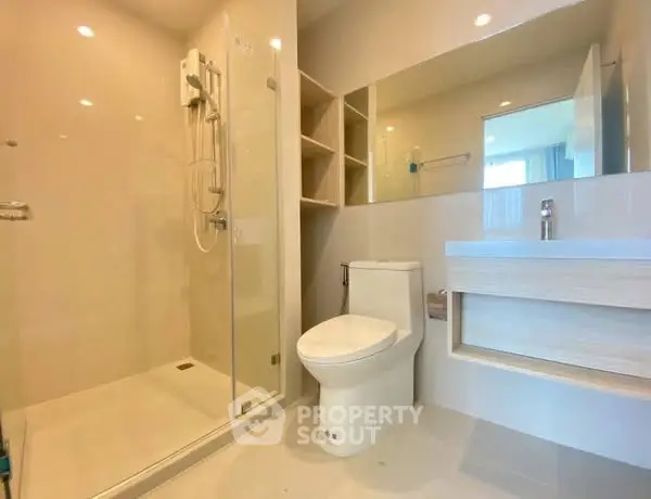 Modern bathroom with glass shower and sleek fixtures in a contemporary apartment.