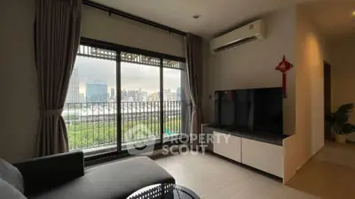 Modern living room with city view, large window, and sleek furniture in urban apartment.