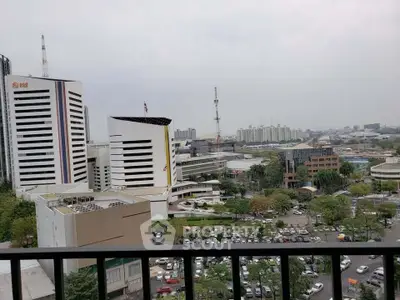 Stunning cityscape view from a high-rise balcony overlooking modern buildings and urban landscape.