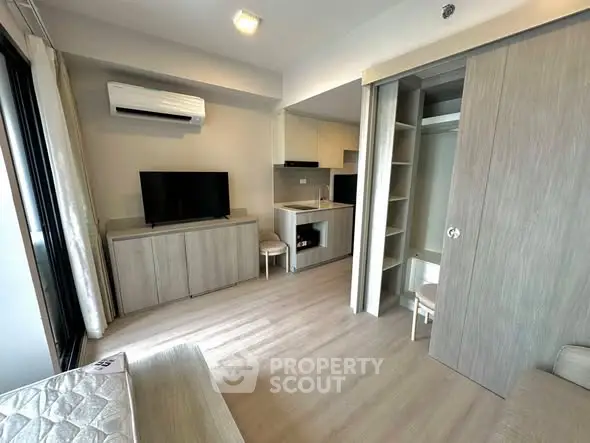 Modern studio apartment with open layout and sleek kitchen design.