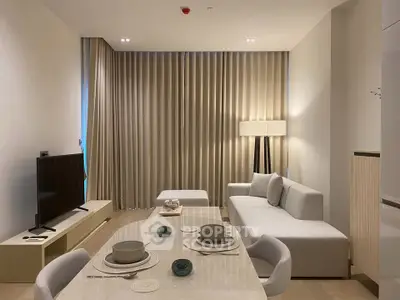 Modern living room with elegant dining setup and cozy seating area, perfect for relaxation and entertainment.