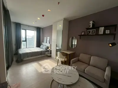 Modern studio apartment with stylish decor and city view, featuring cozy living area and comfortable bed.