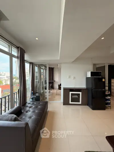 Spacious modern living room with open kitchen and city view balcony