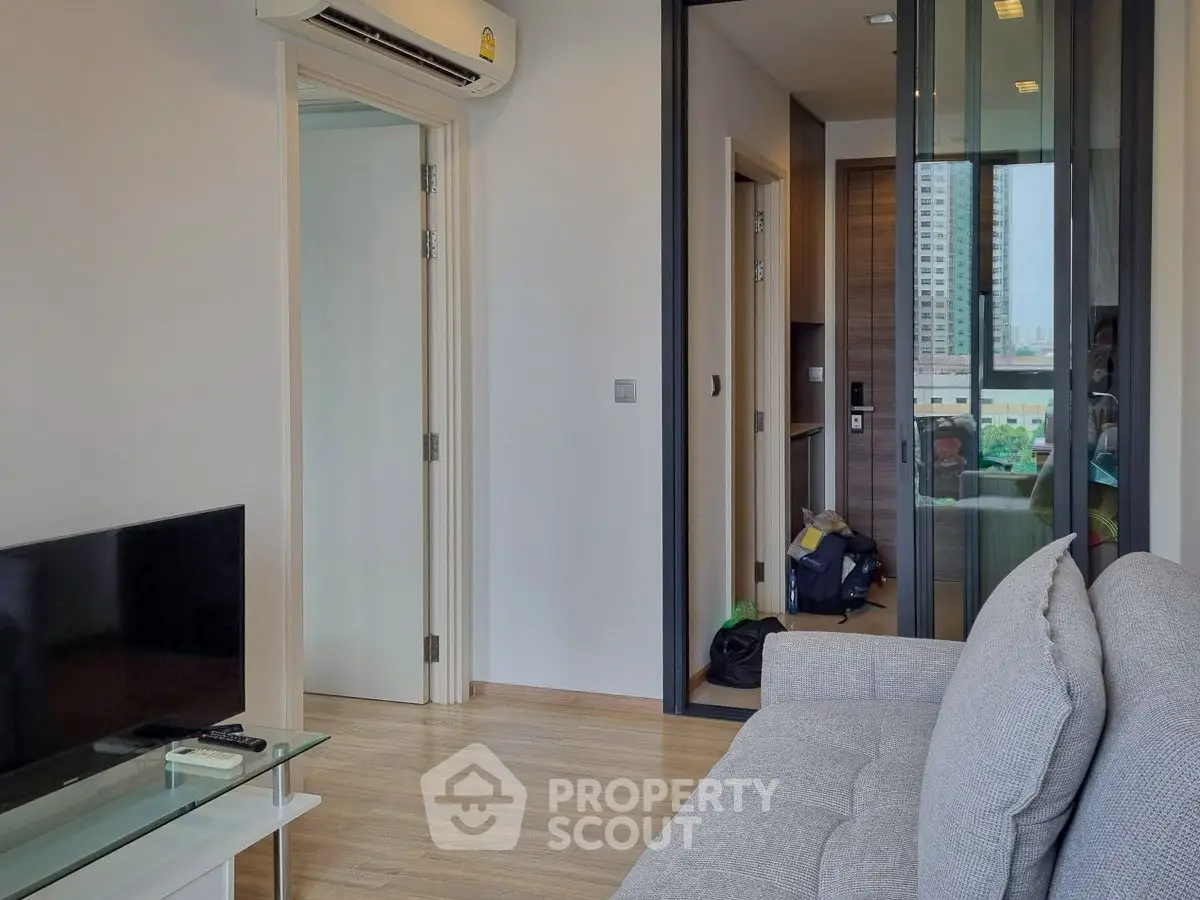 Modern living room with sleek design and city view, featuring a comfortable sofa and glass coffee table.