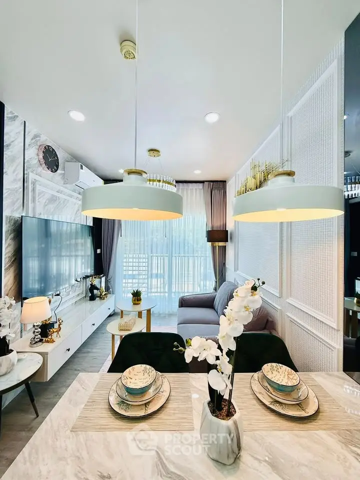 Modern living room with elegant decor and natural light, featuring stylish lighting and a cozy seating area.