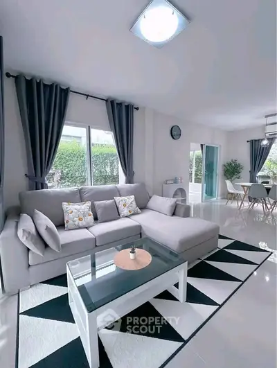 Spacious modern living room with stylish decor and large windows offering natural light.