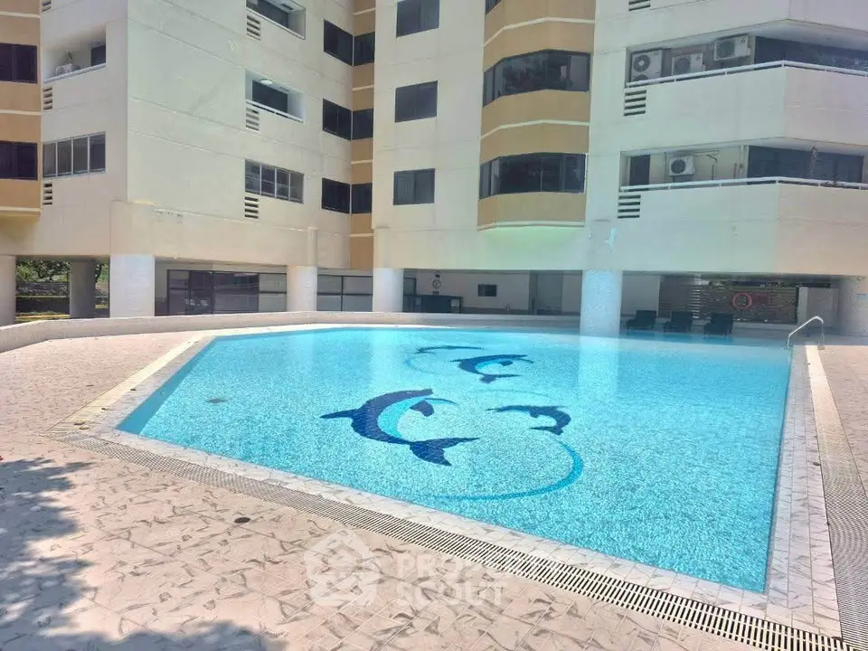 Luxurious apartment building with a stunning outdoor pool featuring dolphin designs, perfect for relaxation.
