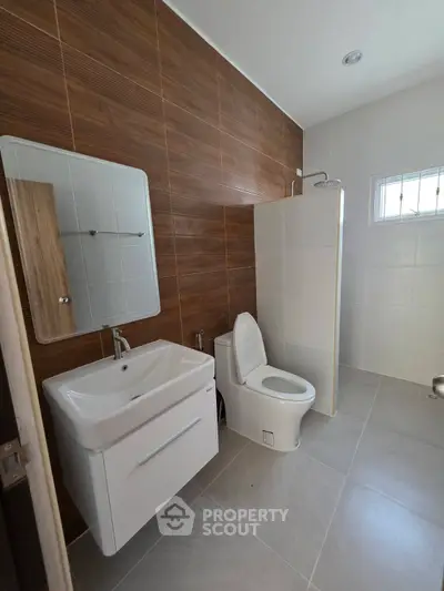 Modern bathroom with sleek fixtures and wood accent wall