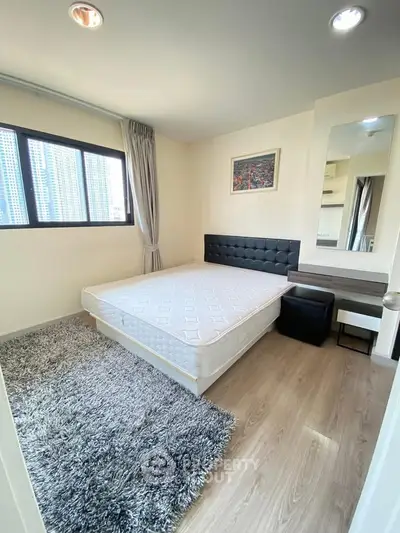 Modern bedroom with stylish decor and city view, featuring a cozy bed and elegant furnishings.