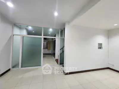 Spacious modern interior with frosted glass partition and tiled flooring, ideal for versatile living space.