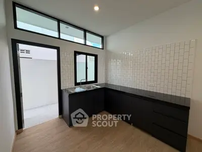 Modern kitchen with sleek black cabinets and white subway tile backsplash