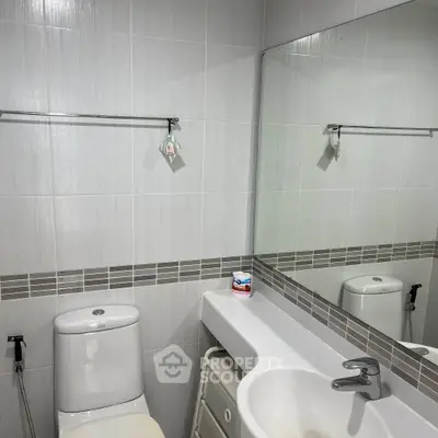 Modern bathroom with sleek fixtures and large mirror, ideal for contemporary living.