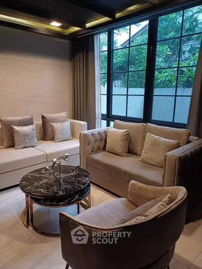 Elegant living room with plush seating and large windows offering natural light.