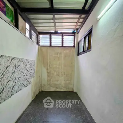 Compact storage room with natural light and tiled flooring, ideal for organizing household items.