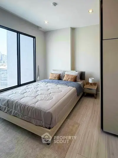 Modern bedroom with large window and stylish decor in urban apartment