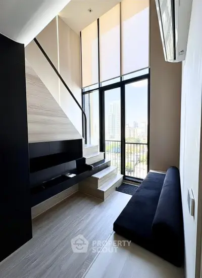 Modern loft-style living room with large windows and city view