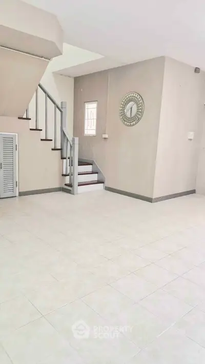 Spacious open-plan living area with staircase and modern decor