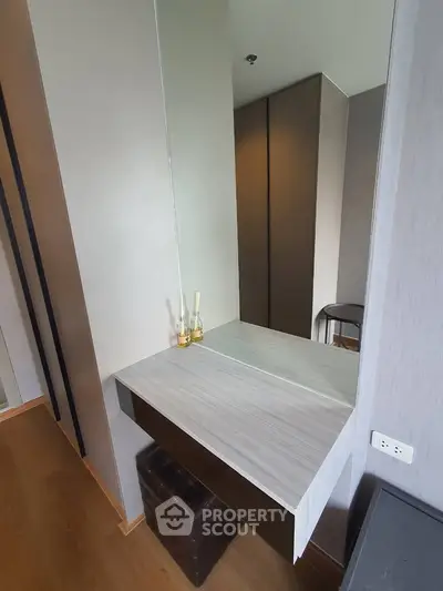 Modern bedroom with stylish vanity and mirror in a contemporary apartment.
