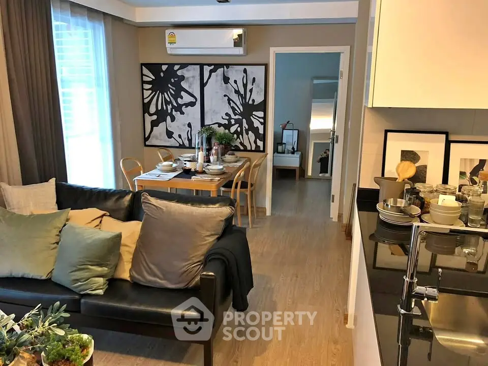 Modern living room with dining area, stylish decor, and natural light in a cozy apartment.
