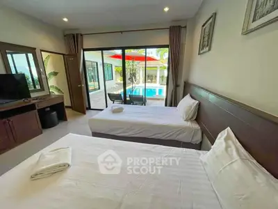 Spacious bedroom with pool view and twin beds in modern villa
